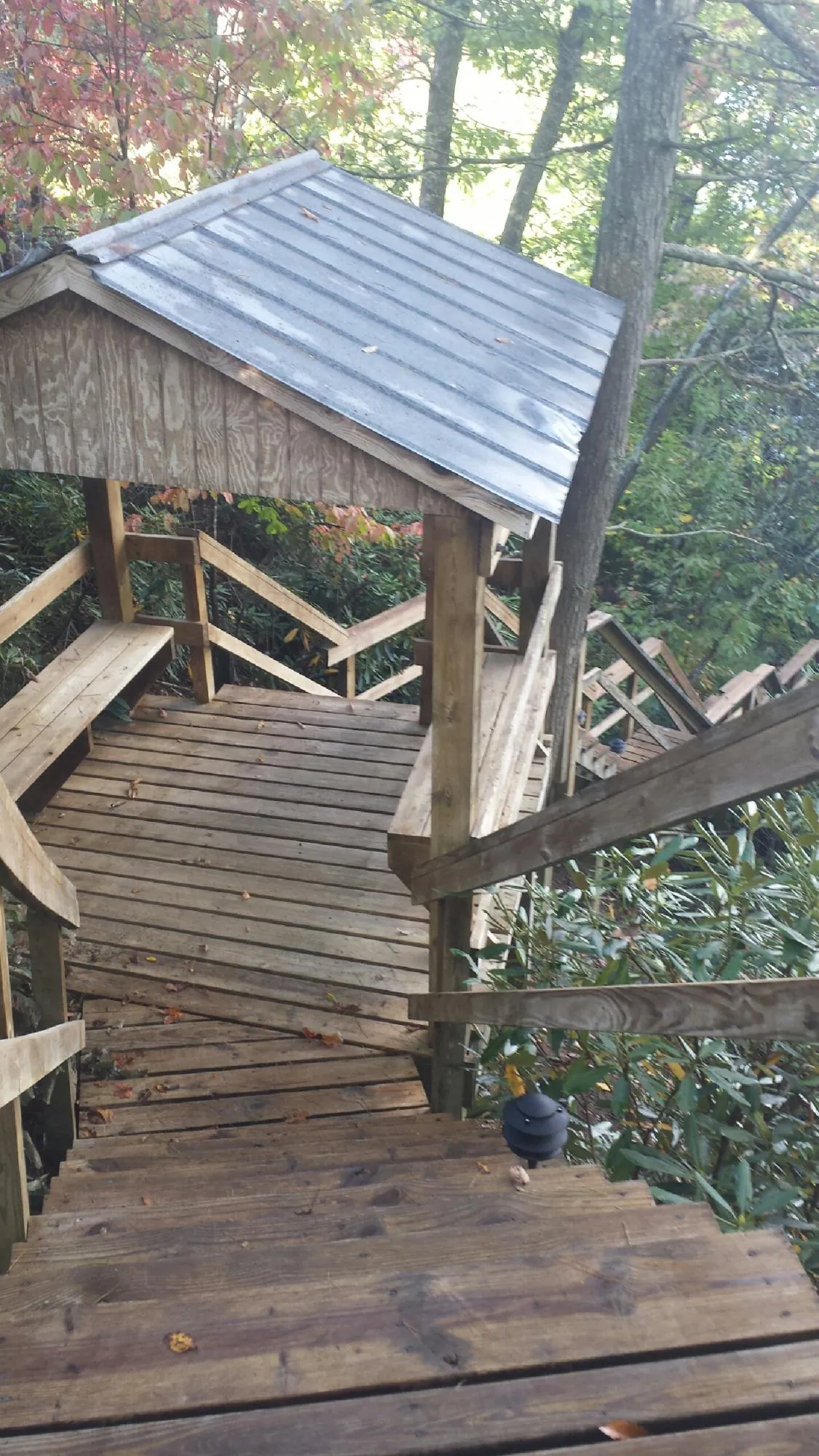 Metal roofed shelter over wooden steps on a wooded walkway — Skylight Repair & Installation work by our crew in West Newfield